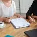 Young female colleagues meeting and discussing business plan, writing strategy scheme on paper, making draft. Cropped shot. Planning concept